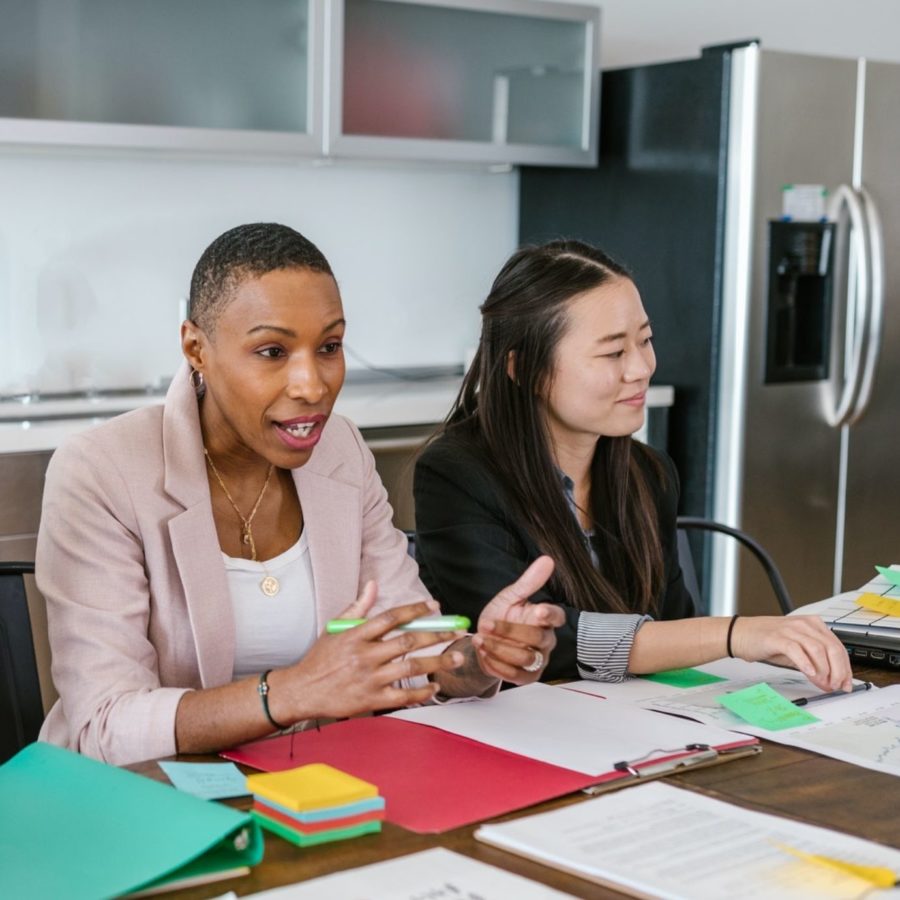 two women sitting at a table talking