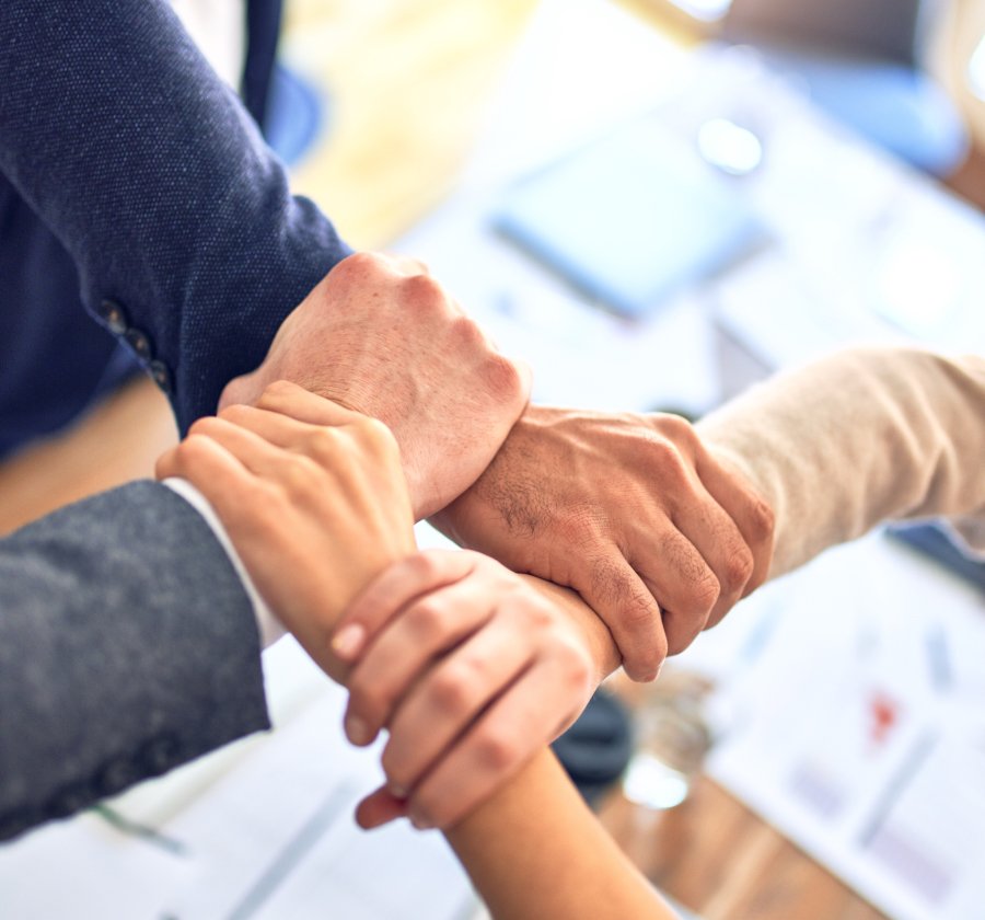 four people joining hands