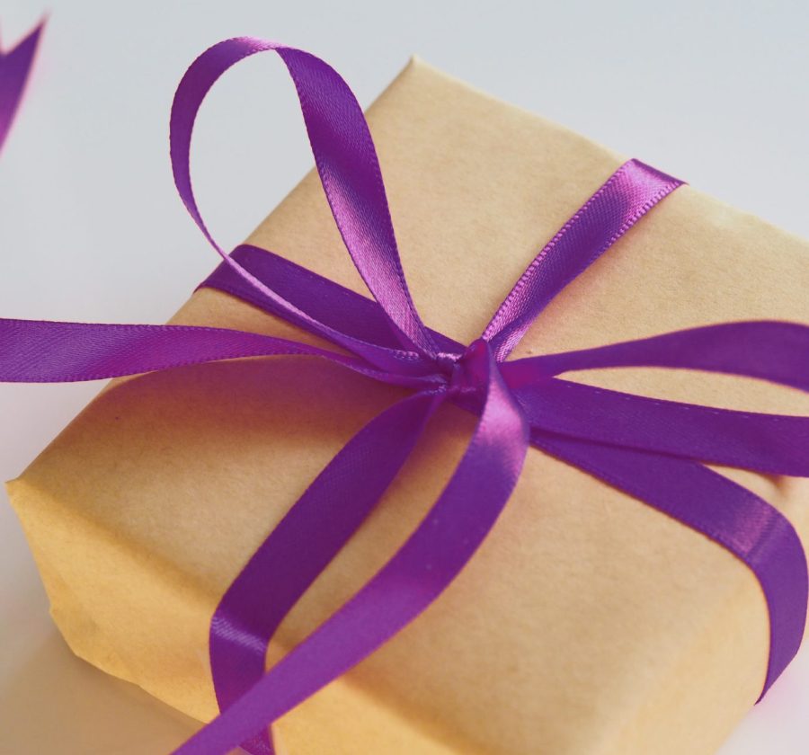 present wrapped in gold with purple bow